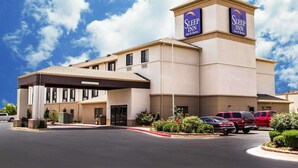 A Sleep Inn hotel with a clear entrance, parking area, and a sign indicating the name.