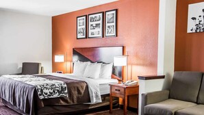 A hotel room with a bed, two bedside tables, a nightstand, a sofa, and a coffee table.