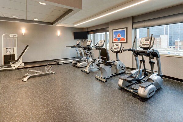 A gym with treadmills, ellipticals, and a weight machine.