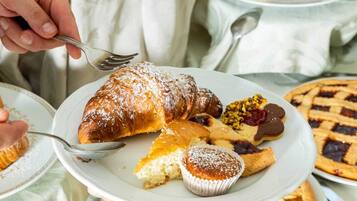 Ein Tisch mit verschiedenen Backwaren, Früchten und einem Kuchen.