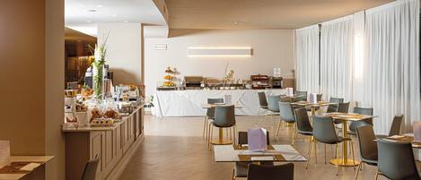 A modern dining area with a long counter, multiple tables, and chairs.