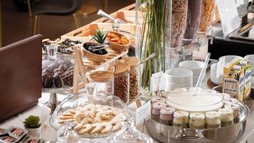 A buffet with various food items, including pastries, fruits, and beverages.