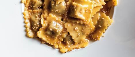 Un plato de ravioles con salsa y semillas de sésamo.
