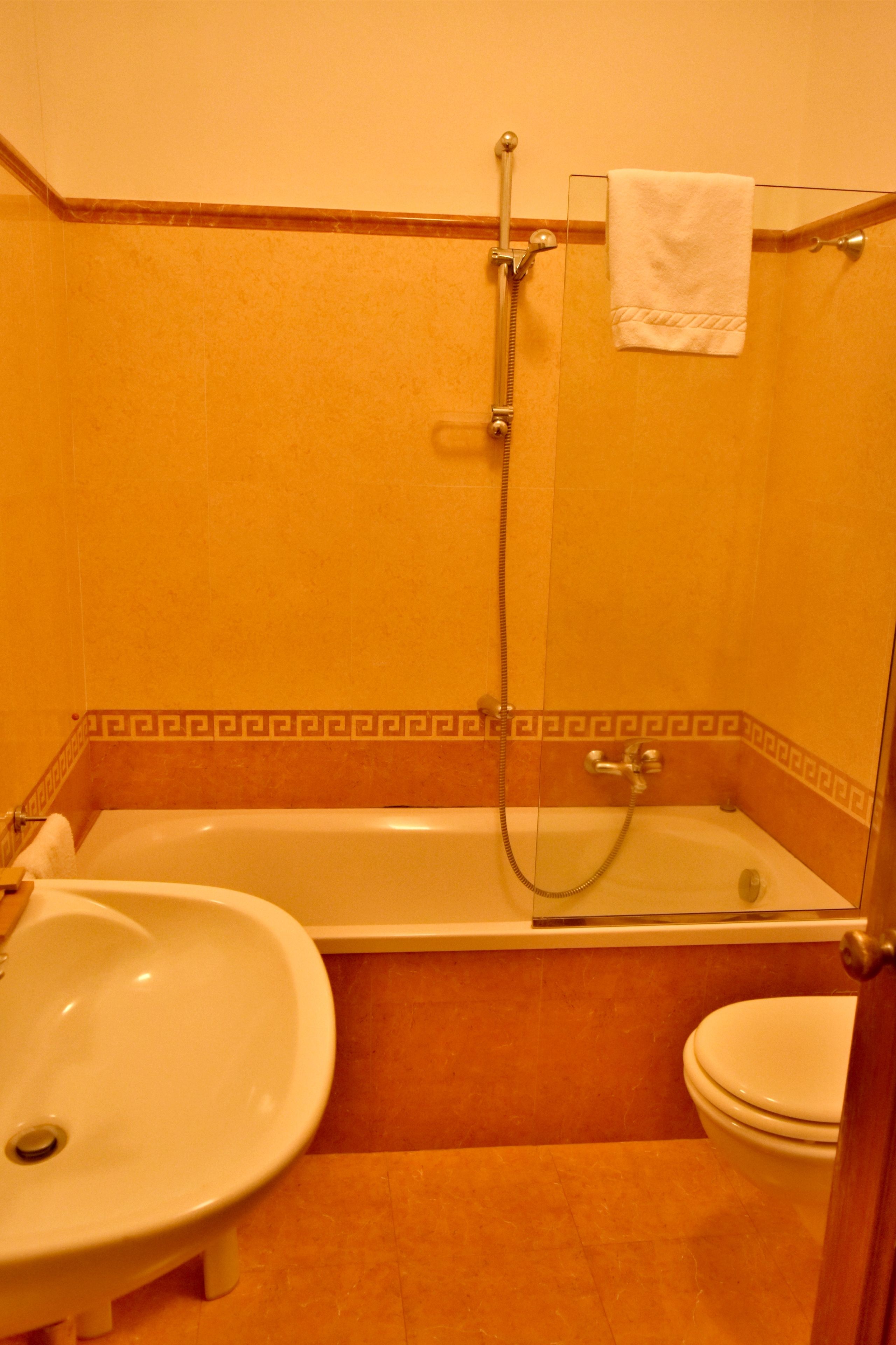 Un baño con bañera, lavamanos e inodoro.