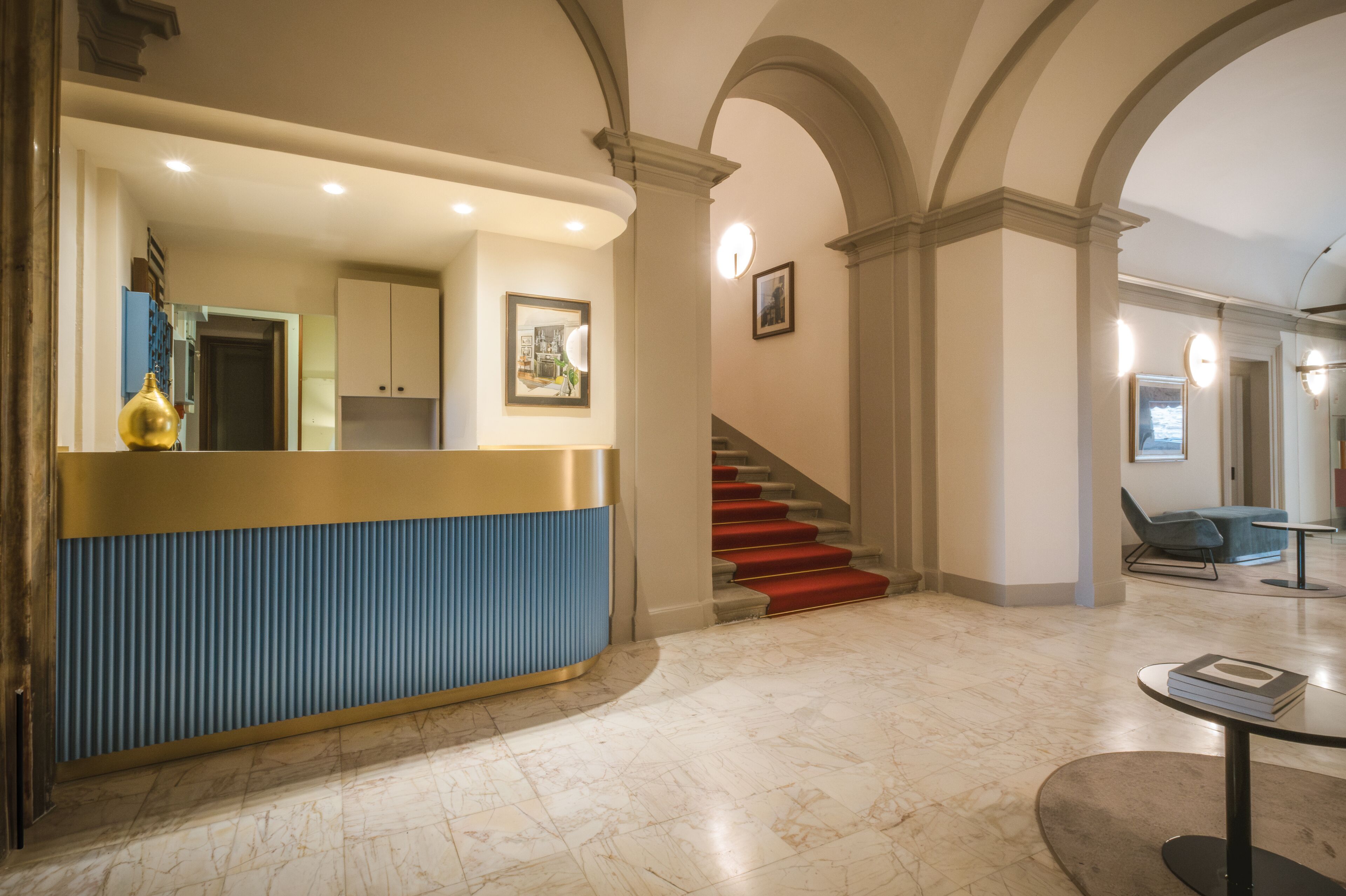 A reception area with a counter, a staircase, and a seating area.