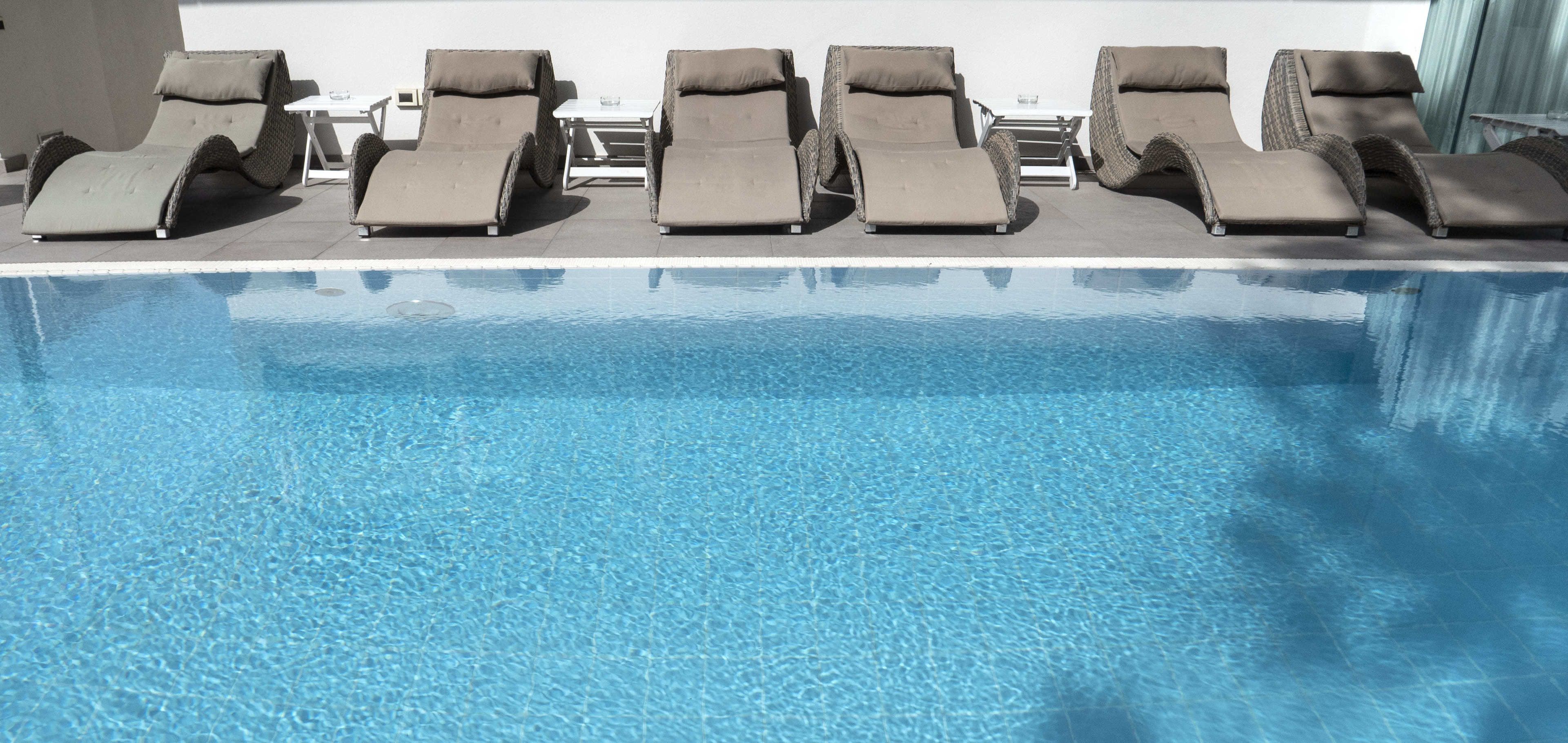 A poolside area with lounge chairs and a table.