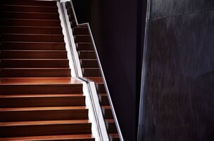 Eine Holztreppe neben einer dunklen Wand.