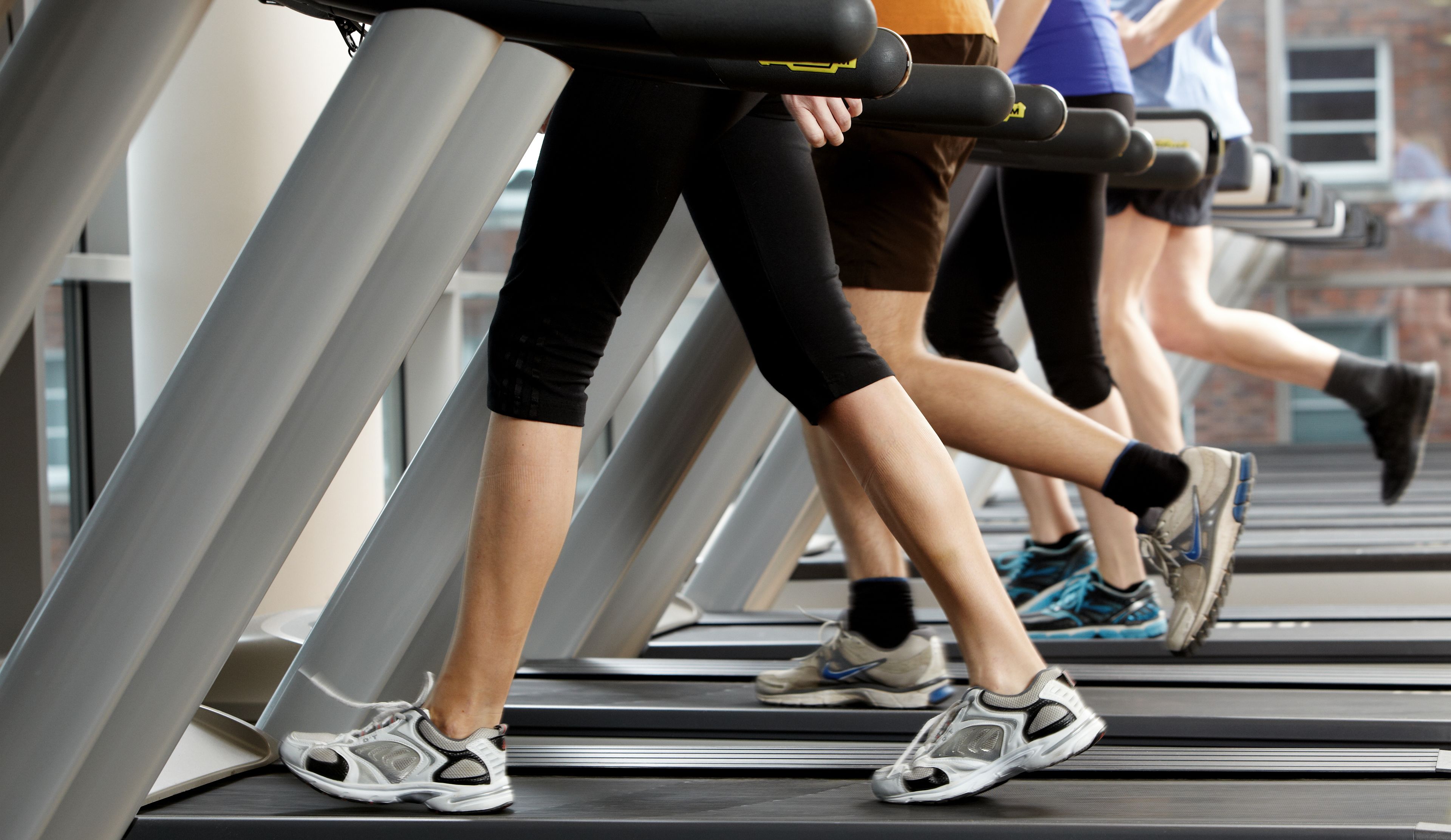 Eine Gruppe von Menschen läuft in einem Fitnessstudio auf Laufbändern.