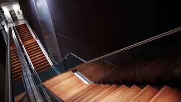A modern staircase with wooden steps and glass railings.
