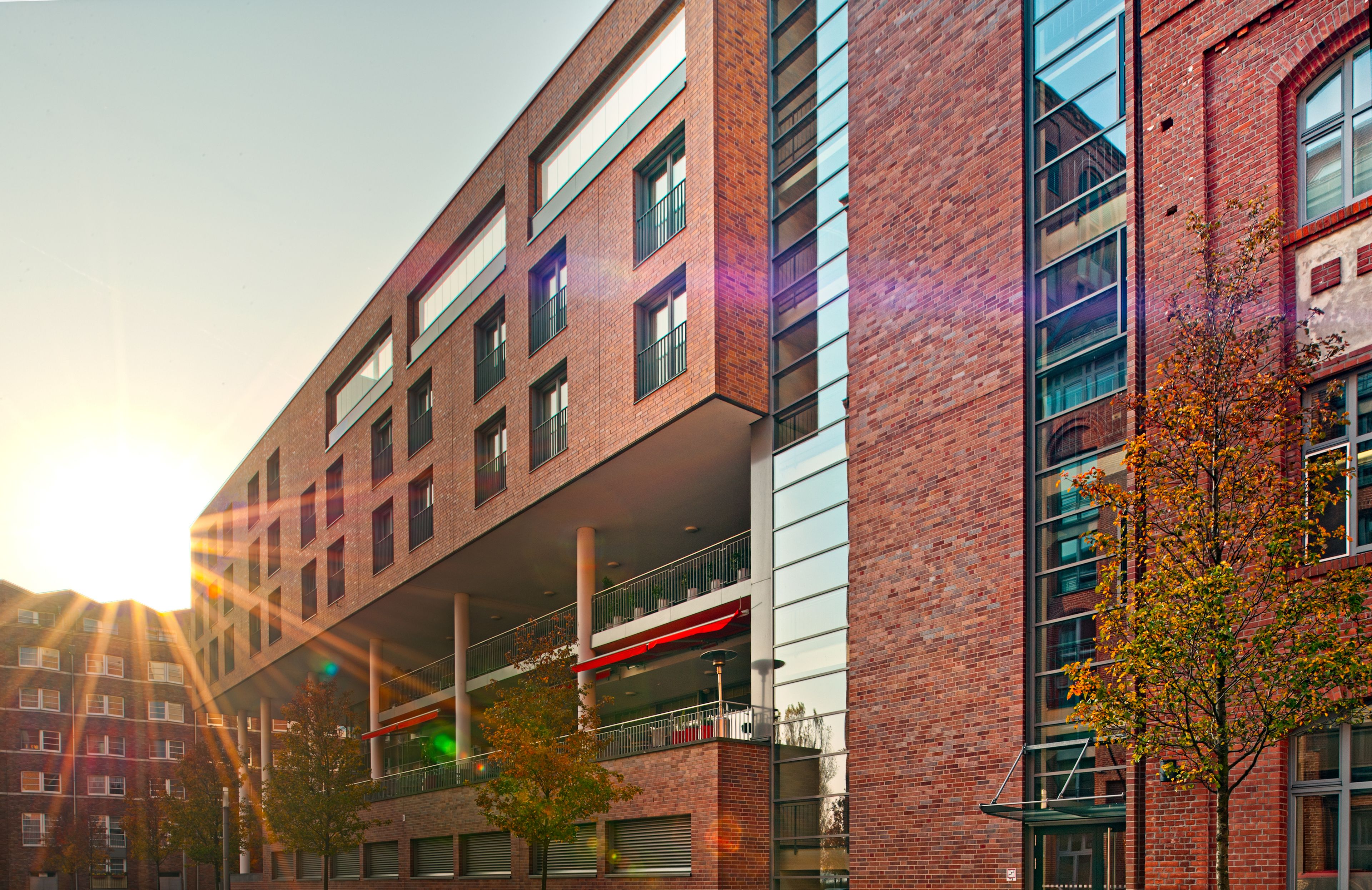 A multi-story building with a brick facade, large windows, and balconies.