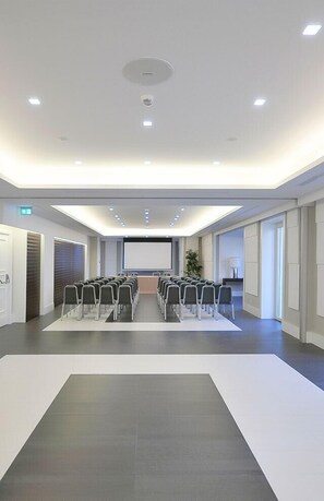 A conference room with rows of chairs, a projector screen, and a large whiteboard. - Grand Hotel Oriente (Naples)