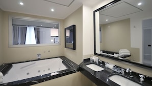 Une salle de bain avec une grande baignoire, deux lavabos et des miroirs.