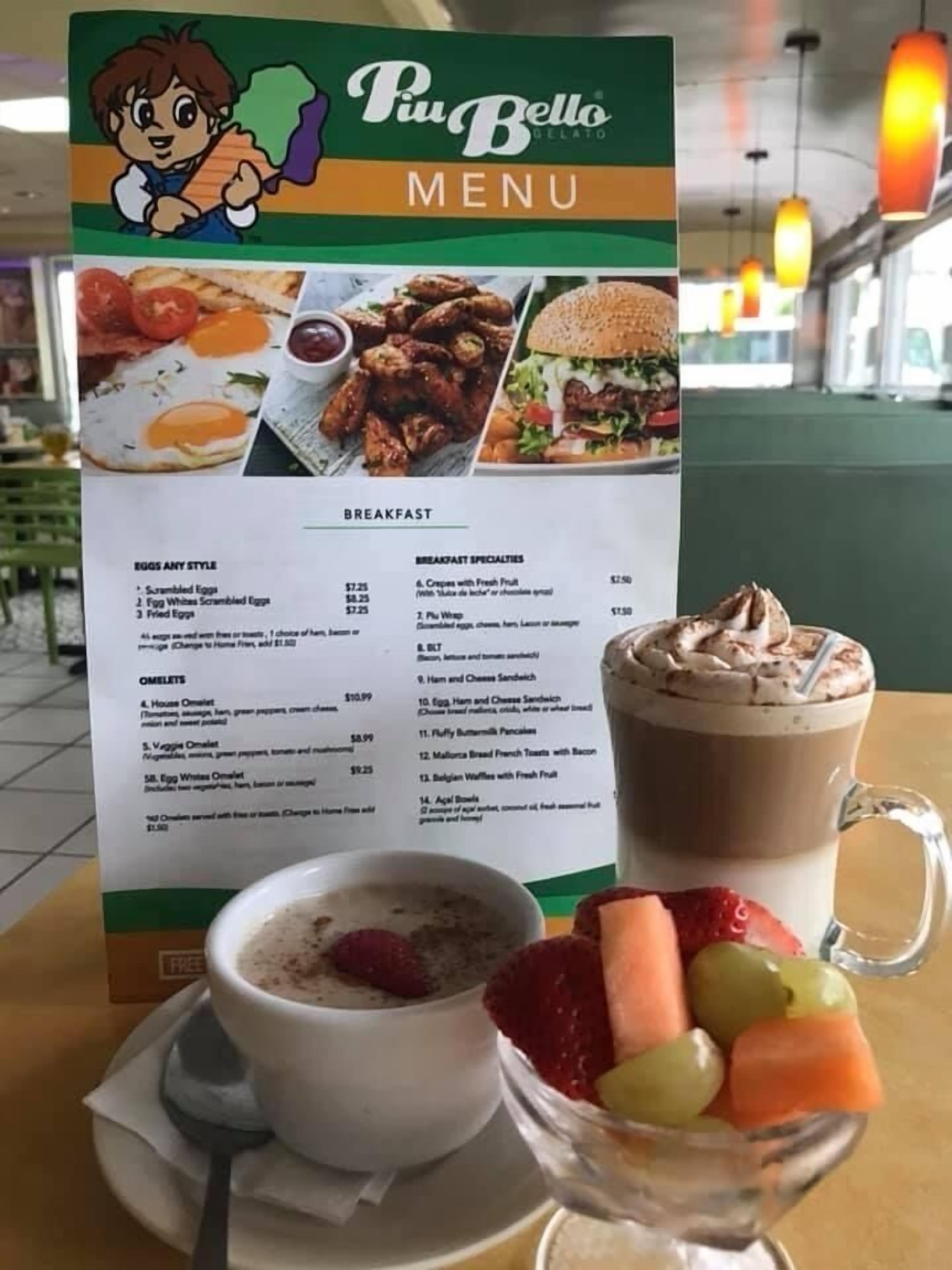 Tablero de menú en Piu Bello Gelato con opciones de desayuno y precios.