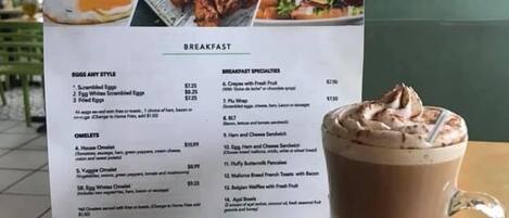 Tablero de menú en Piu Bello Gelato con opciones de desayuno y precios.