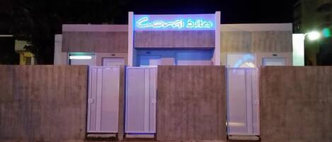 Ein Gebäude mit einer Neonreklame, auf der "Coral Suites" steht, bei Nacht.
