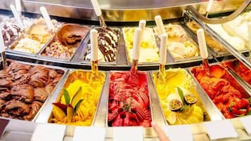 Variedad de sabores de helado en un congelador, cada uno con un asa blanca.