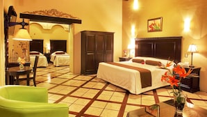 Une chambre d’hôtel comprenant un lit, deux tables de chevet, une chaise, une armoire et un miroir.