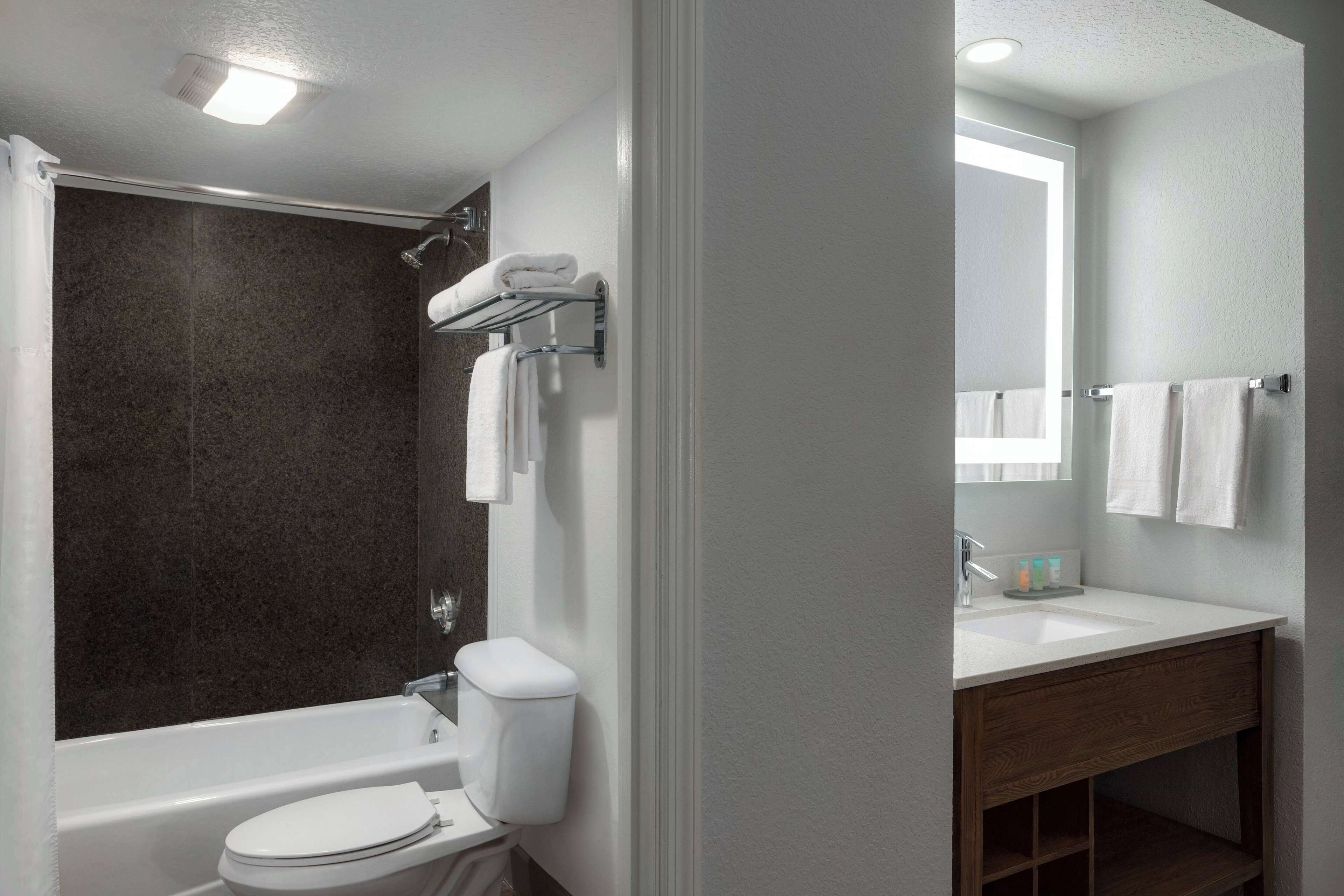 A modern bathroom with a bathtub, toilet, and sink.