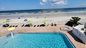 Zona de piscina con vista a la playa y al océano.