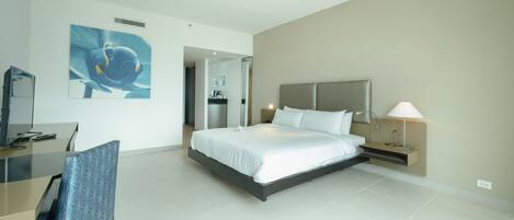 A modern hotel room with a large bed, a desk, and a chair.