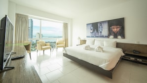 Une chambre d’hôtel moderne dotée d’un grand lit, d’une télévision, d’un bureau et offrant une vue sur la ville.