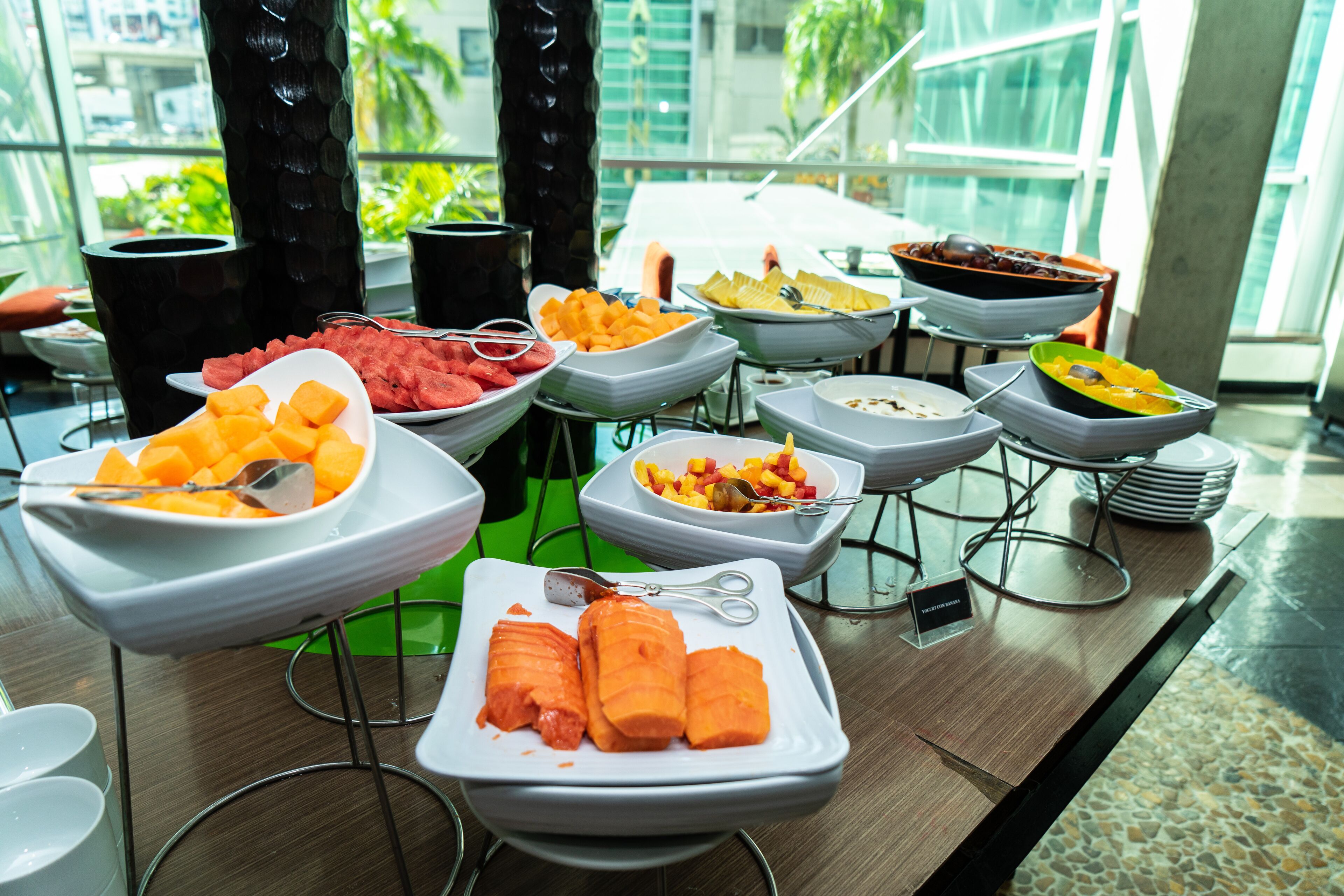 Ein Buffet mit verschiedenen Speisen, darunter Wassermelone, Mango und anderem Obst.
