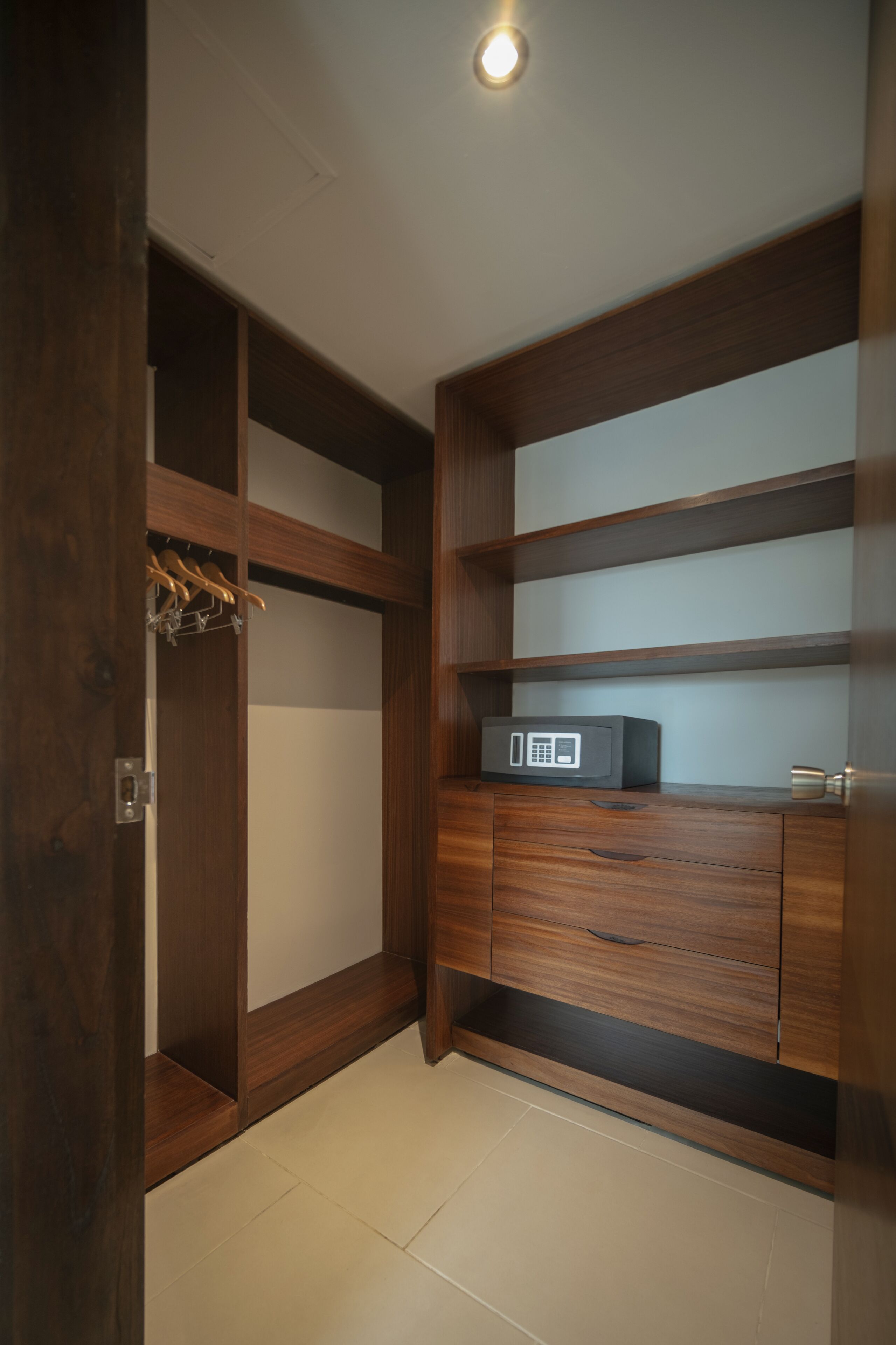 A walk-in closet with wooden shelving and a microwave.