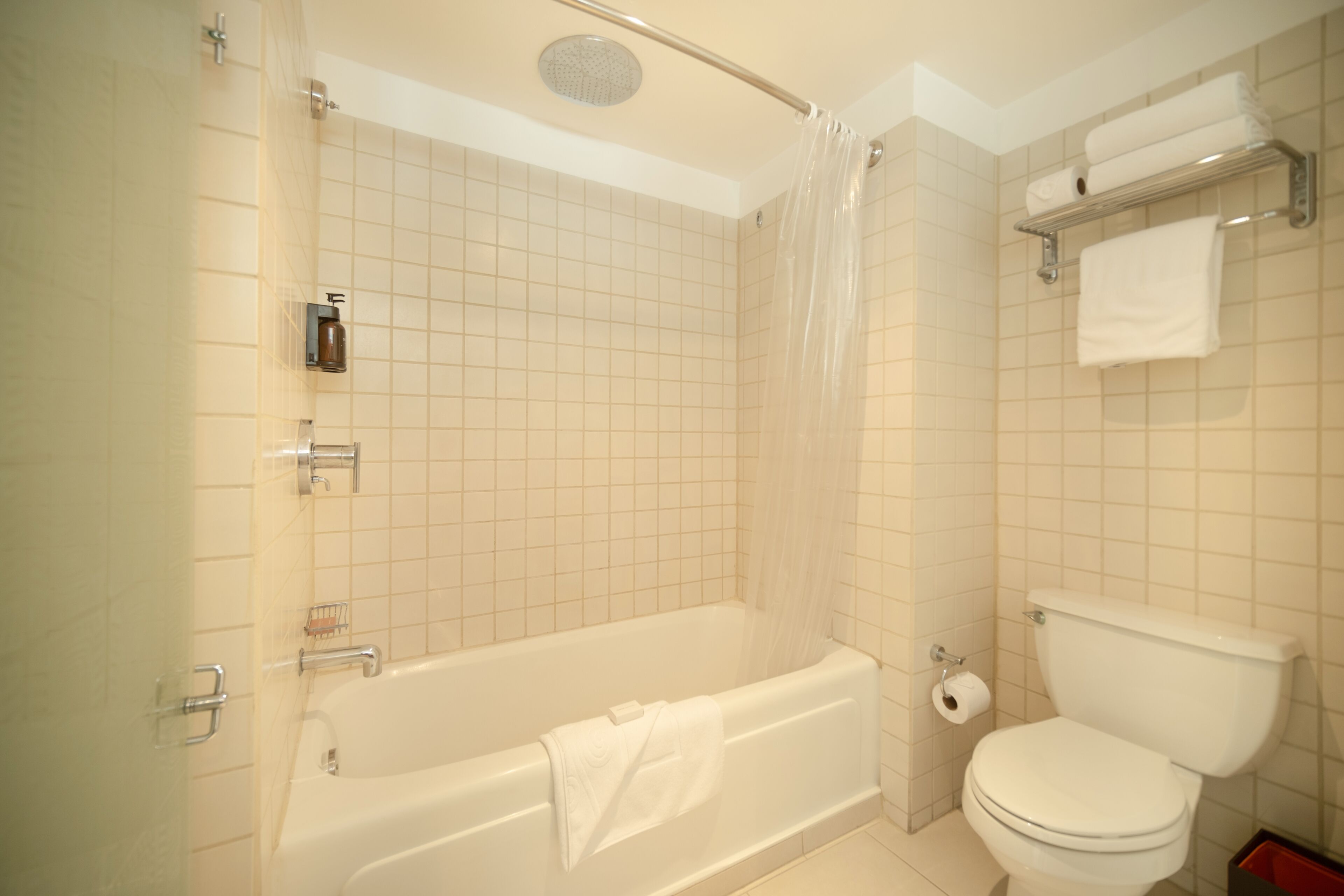 A bathroom with a bathtub, toilet, and shower curtain.