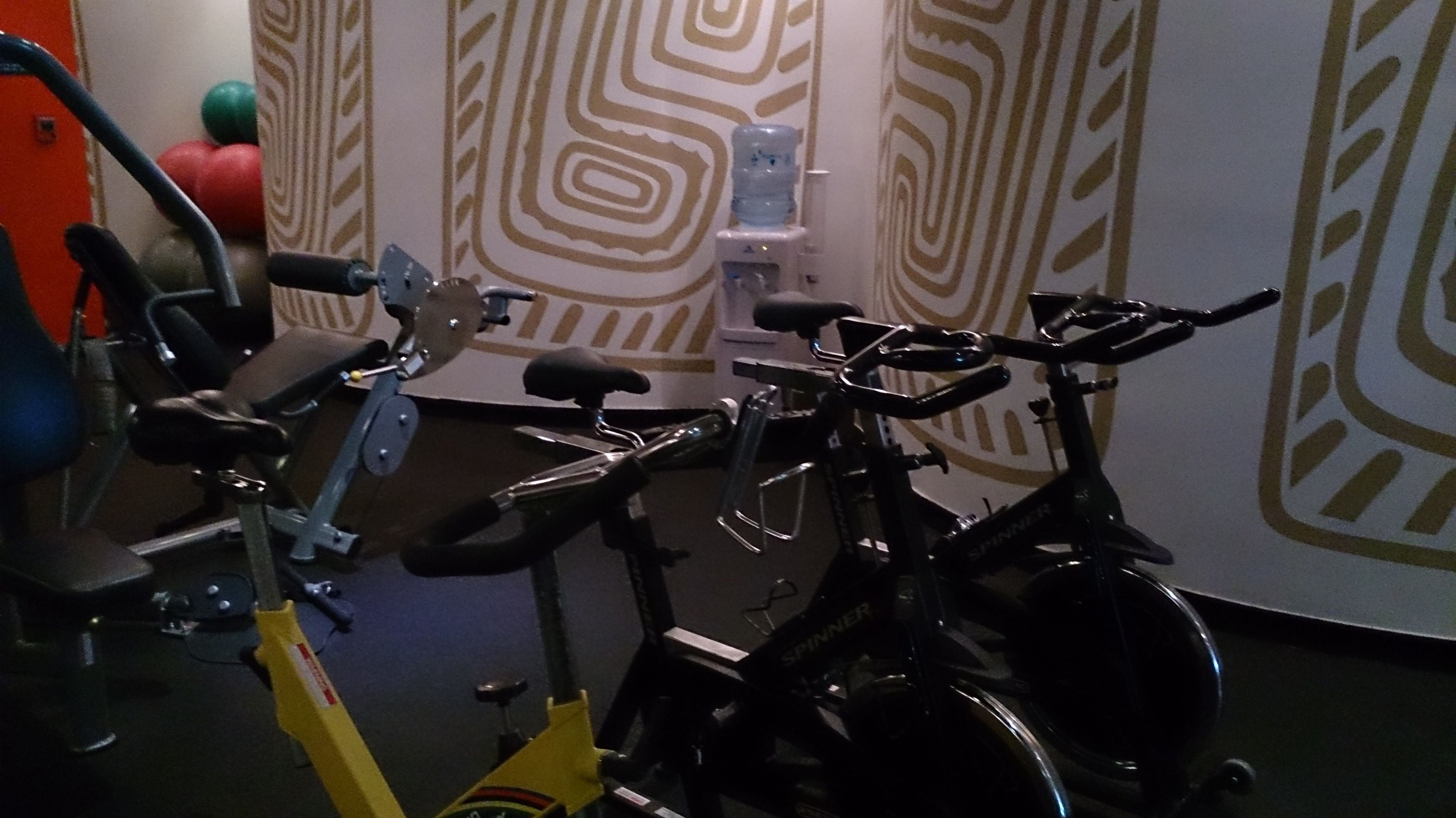 A gym with stationary bikes and a water dispenser.