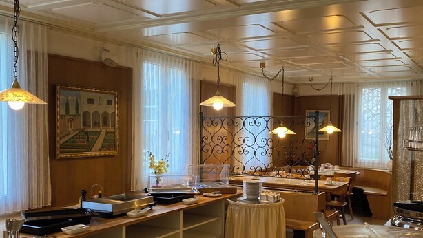 Un espace de restauration d’hôtel avec un buffet, comprenant divers récipients pour les aliments et un vase décoratif.