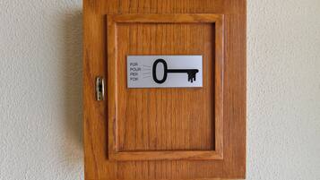 Un armario de madera con un letrero con forma de llave en la puerta.