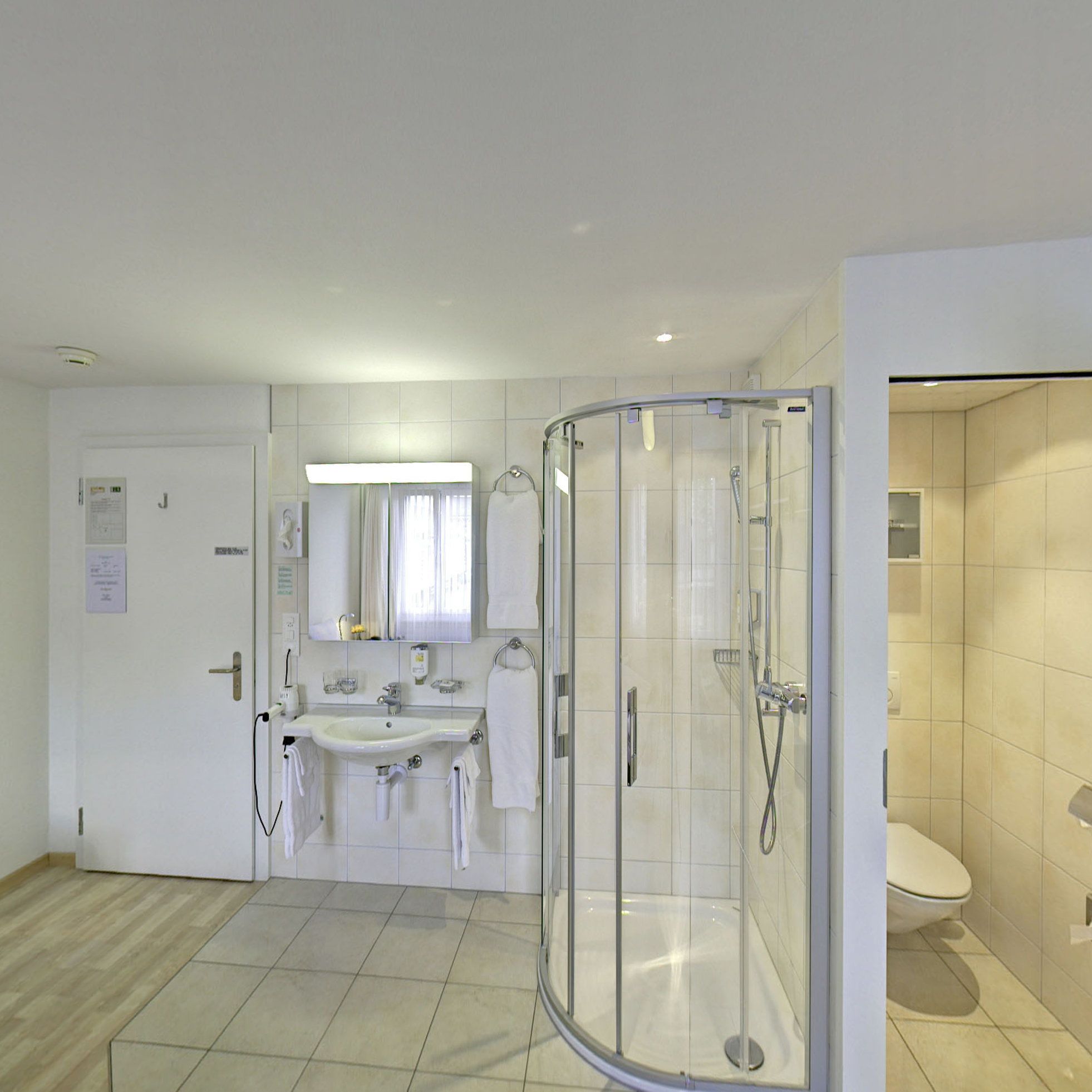 Une salle de bain moderne avec une douche à parois de verre, un lavabo et des toilettes.