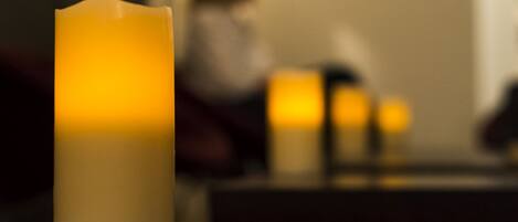 A candle on a table with a blurred background.