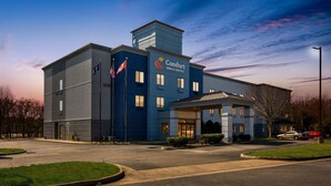 Um hotel Comfort Inn & Suites com design moderno, apresentando uma entrada notável e área de estacionamento.