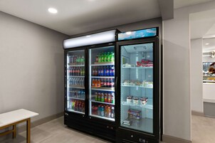 Una fila de máquinas expendedoras de bebidas con diversas opciones.