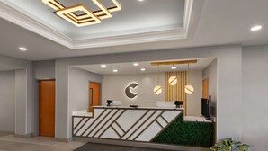 Uma receção moderna com design geométrico, um painel de parede verde e iluminação pendente.