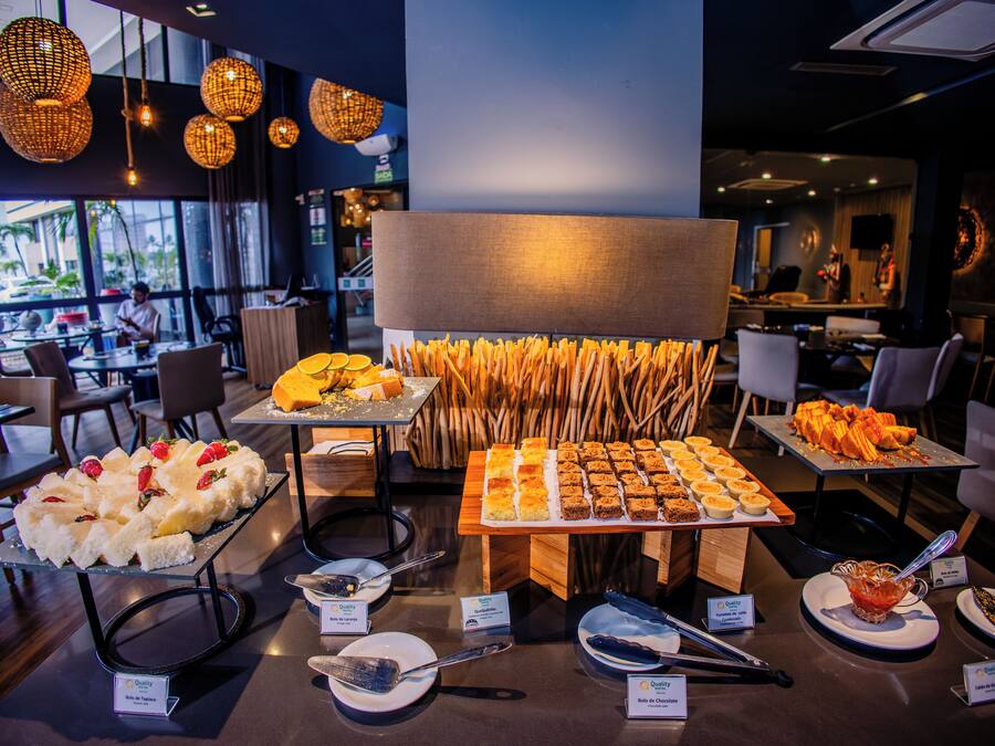 A buffet with various desserts and a seating area with tables and chairs.