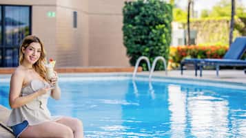 Een buitenzwembad, parasols voor strand/zwembad