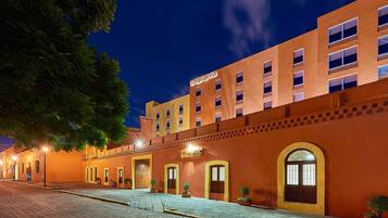 Un hotel con fachada de ladrillo, varias puertas y un letrero que dice 'cityexpress'.