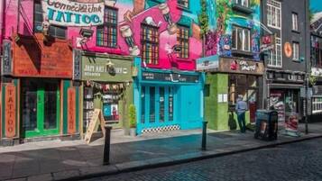 A colorful building with a visible tattoo shop and a sign for a skate shop.