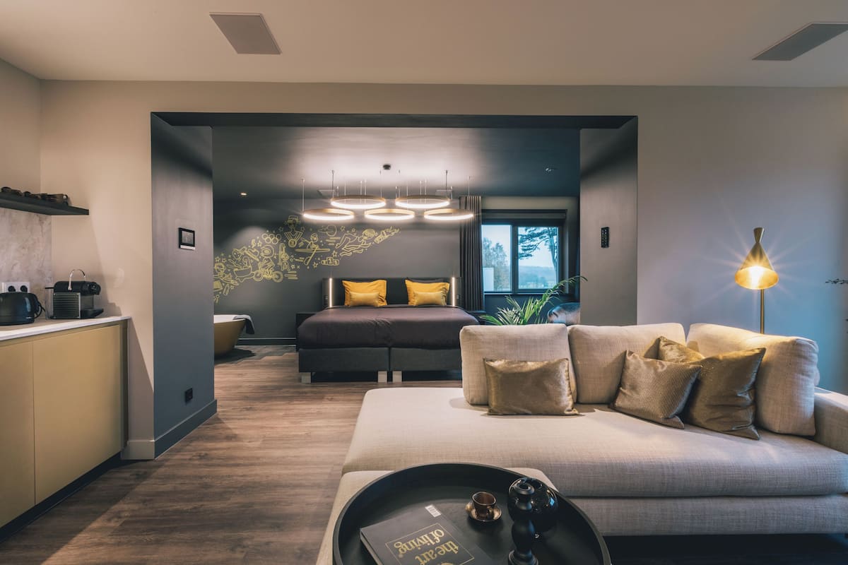A modern interior with a kitchen, a sofa, and a bed with a view.