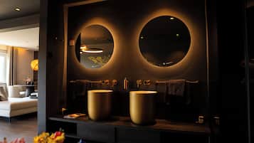 Une salle de bain moderne avec deux grands miroirs, un lavabo rond et un porte-serviettes.