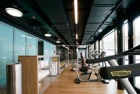 A gym with exercise equipment, wooden flooring, and large windows. - Hotel Papendal (Arnhem)