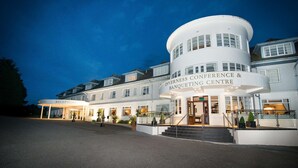 A large, white building with a curved facade, labeled "Inverness Conference & Banquetting Centre." - Macdonald Drumossie Hotel (Inverness)