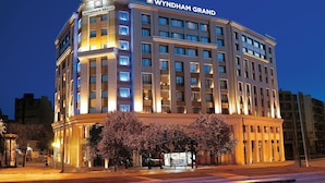 A multi-story hotel with a prominent 'WYNDHAM GRAND' sign at the top. - Zeus Wyndham Grand Athens (Athens)