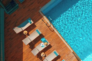 Een seizoensgebonden buitenzwembad, parasols voor strand/zwembad