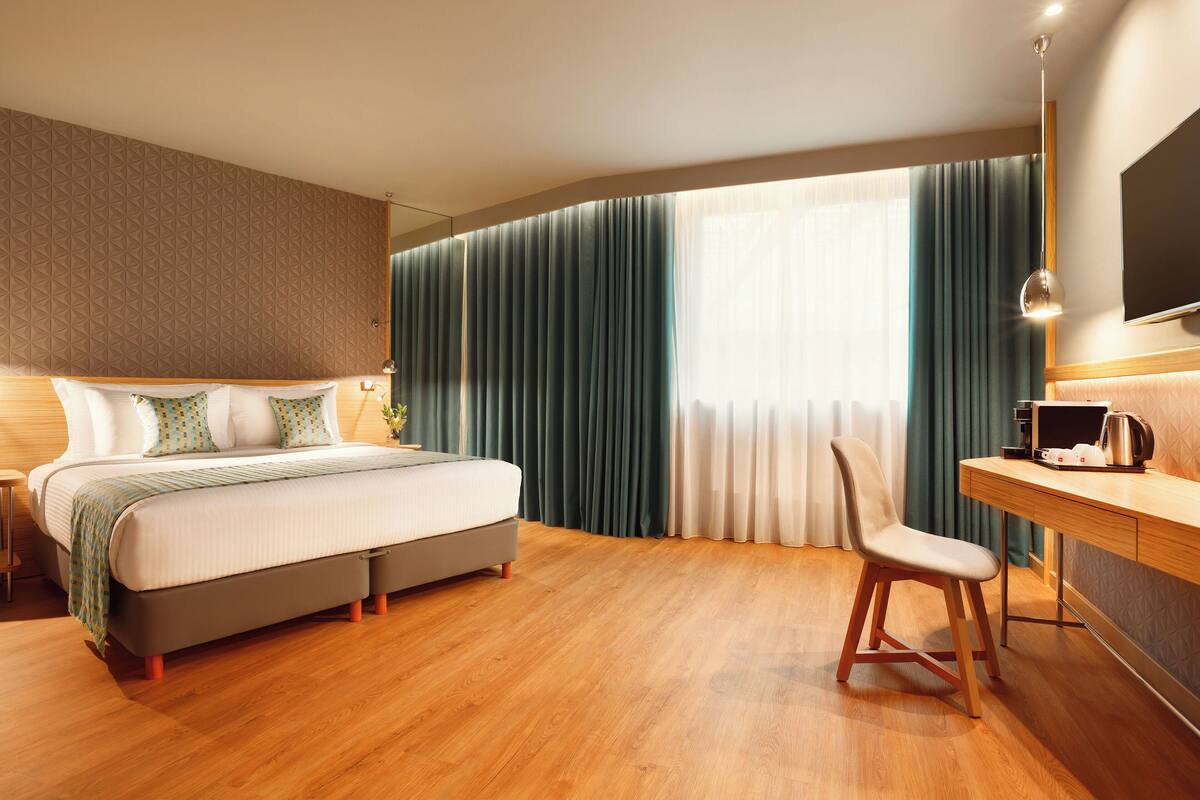 Una camera d'albergo moderna con un letto, una scrivania e una sedia.