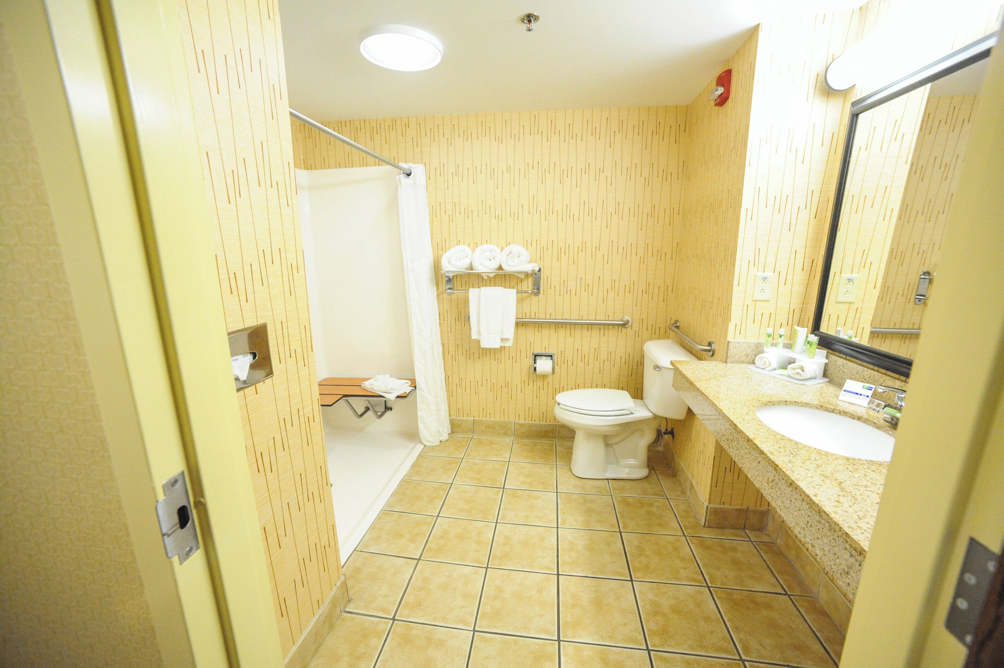 A bathroom with a shower, toilet, and sink.