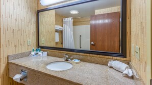 A bathroom with a wooden wall, a sink, a mirror, and a shower. - Holiday Inn Express Hotel & Suites Bowling Green by IHG (Bowling Green)