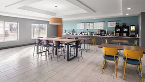 Un restaurant moderne doté d’un bar, de plusieurs espaces de restauration et offrant une vue sur l’extérieur.